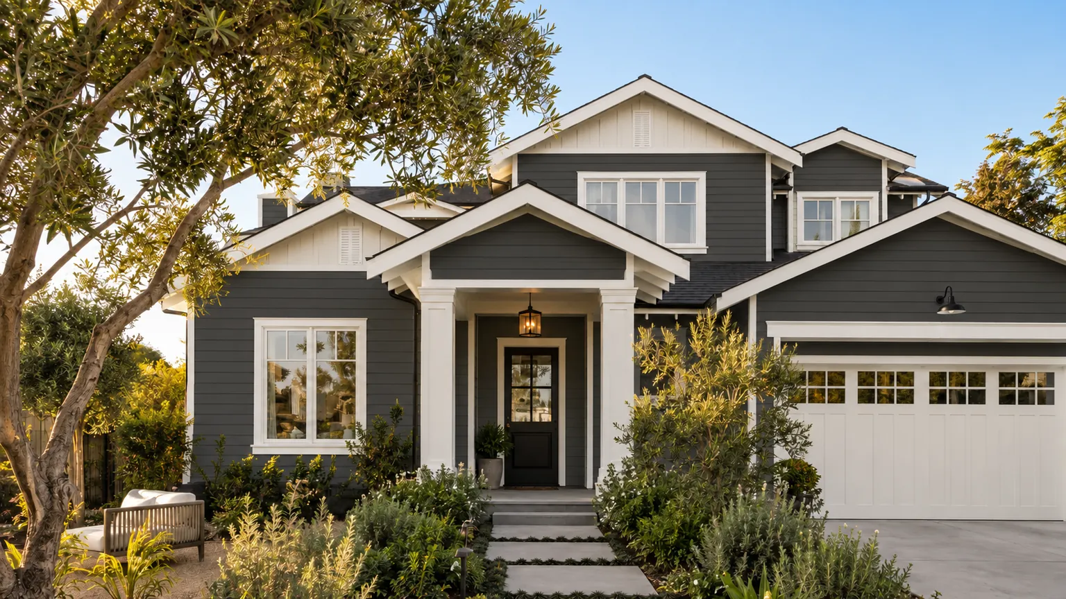 The same house before: dark charcoal siding, same trim, landscaping and light.